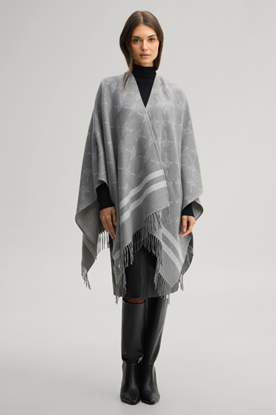 Leads to product detail page "Cornflower poncho in grey and ecru pattern"
