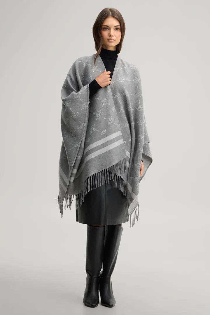 Leads to product detail page "Cornflower poncho in grey and ecru pattern"
