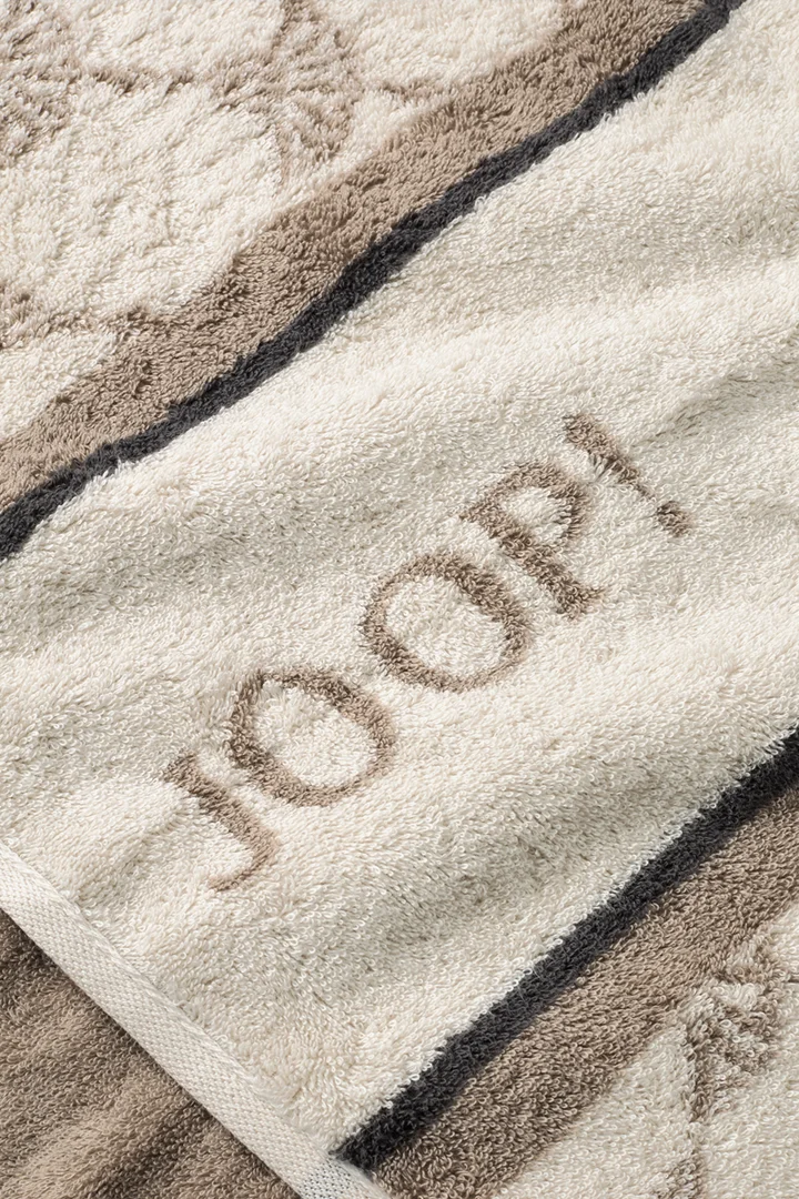 Leads to product detail page "Joop! sauna shower towel in cream and light brown with a pattern"