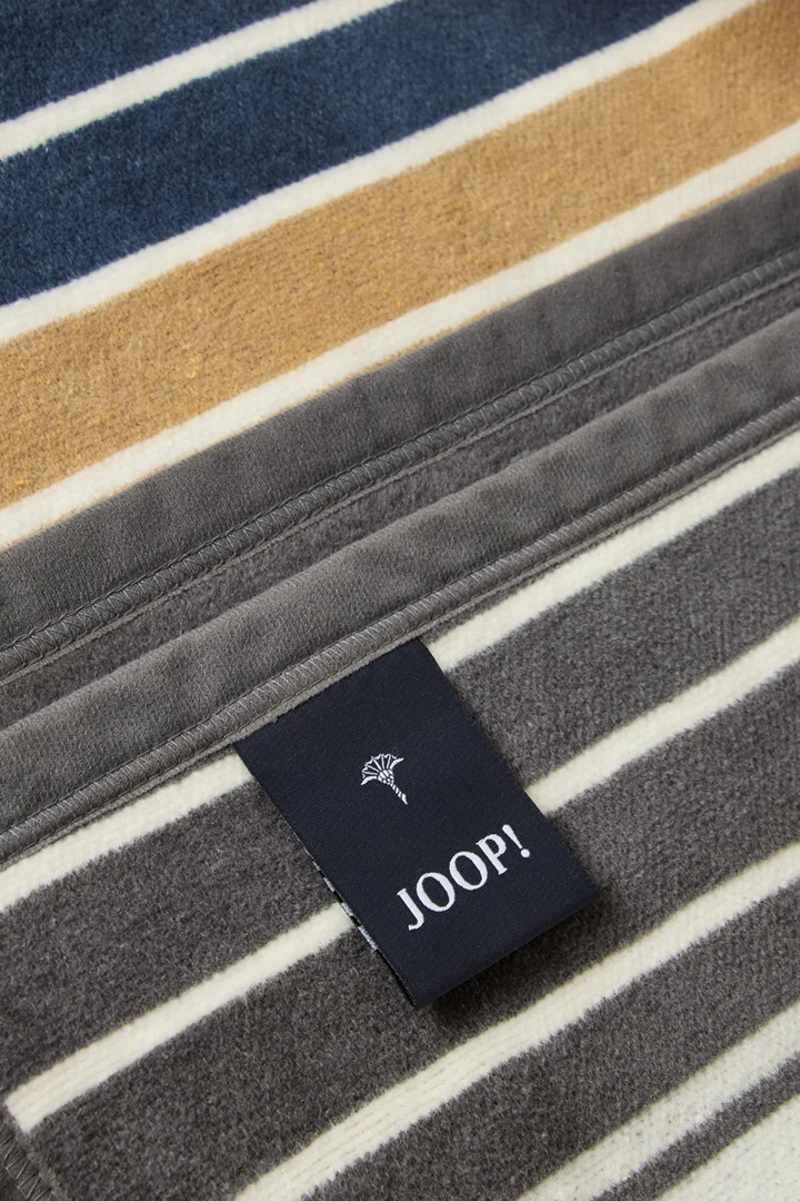 Führt zu Produktdetailseite „Wohndecke JOOP! OUTDOOR LIFESTYLE in Curry/Stein, 125 x 170 cm"